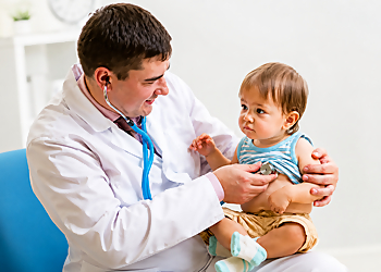 Carlos A. Cruz, MD - Alexandria, VA Pediatricians - Doctor With Patient Image