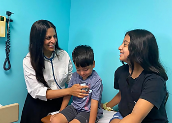 Seema Dhar, MD - Newark, NJ Pediatricians - Doctor With Patient Image